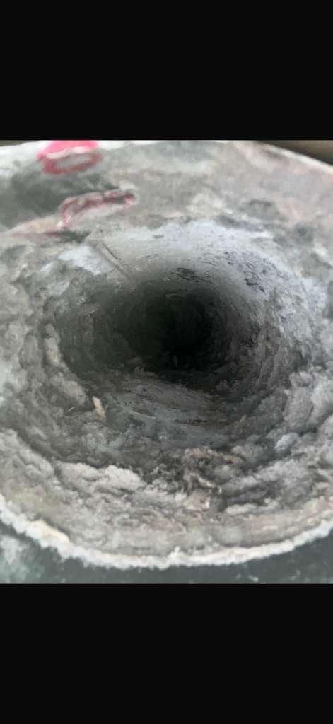 Dryer duct opening coated in compacted lint