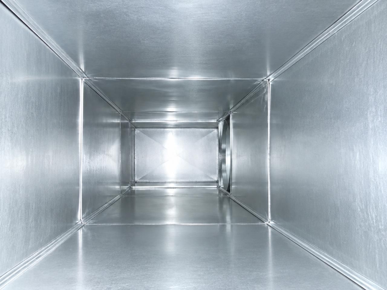 The same run of sheet-metal duct after cleaning, the bare galvanised metal bright and clear