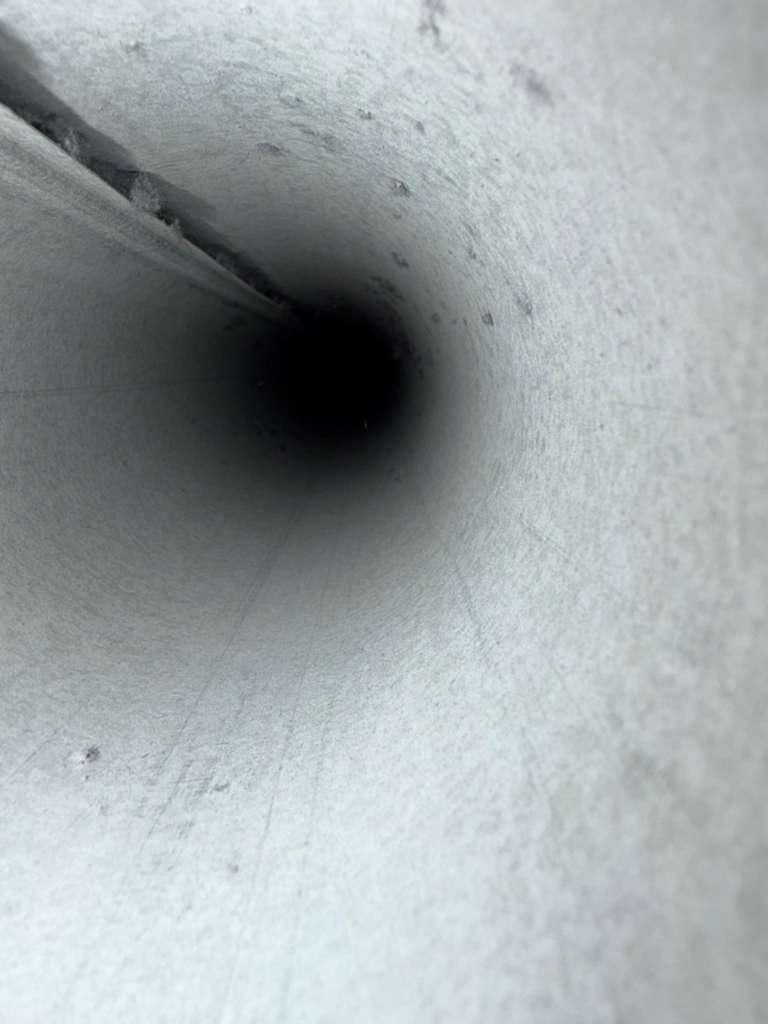Bright, clean metal duct interior seen down a spiral run