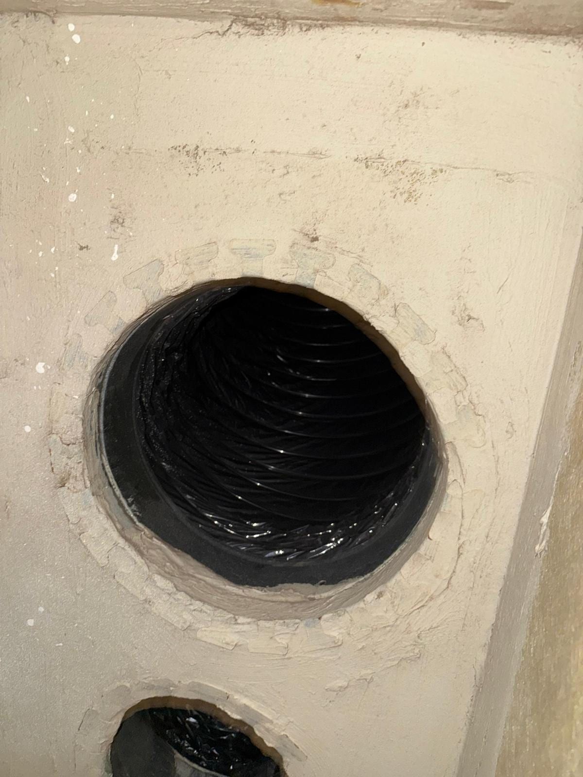 Clean, dark insulated duct interior with a collar joint, receding into shadow