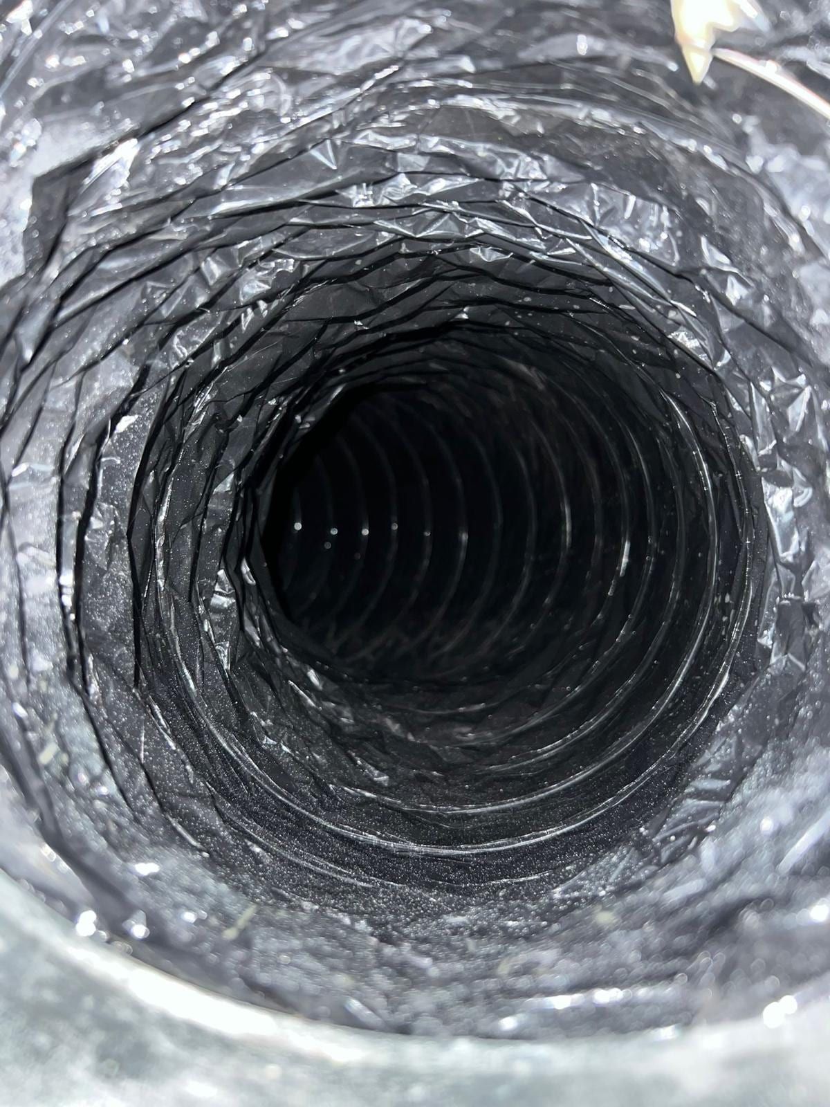The inside of a flexible duct run after cleaning, its ribbed lining clear of dust
