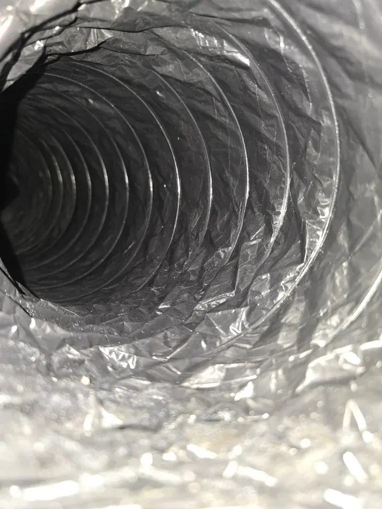 Interior view of a residential ductwork system showing flexible air ducts and insulation.